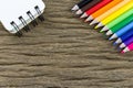 Color pencil and notepad on a wood grain background Royalty Free Stock Photo