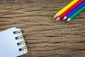 Color pencil and notepad on a wood grain background Royalty Free Stock Photo