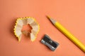 Color pencil, sharpener and shavings on orange background Royalty Free Stock Photo