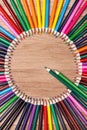 Color pencils arranged in a circle on wooden background, top view Royalty Free Stock Photo