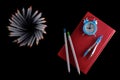 Color pencils with book and clock on black background Royalty Free Stock Photo