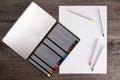 Color pencils in case and blank paper on wooden table Royalty Free Stock Photo