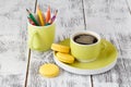 Color pencils in a green cup with greenish mug of coffee Royalty Free Stock Photo