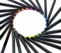 Color pencils isolated on the black background forming a circle. Rays of color pencils