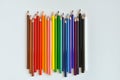 Color pencils laid out by a wave on a white background. Royalty Free Stock Photo