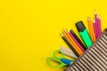 Color pencils in a school pencil case on a bright paper yellow background. Office tools. education. top view Royalty Free Stock Photo