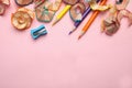 Color pencils, sharpener and shavings on pink, top view. Space for text Royalty Free Stock Photo