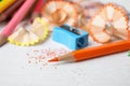 Color pencils, sharpener and shavings on white table Royalty Free Stock Photo