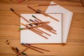Color pencils and sketchbook on wood table Royalty Free Stock Photo