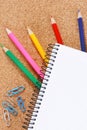 Color pencils under blank notebook