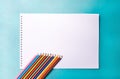 Color pencils on white album for drawing on blue background. Close up Royalty Free Stock Photo