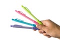 Color pens in hand that hold together many colors. Has a white background.