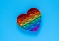 Color pop it antistress toy for children. rainbow heart shaped isolated on blue background .