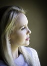 Profile portrait of gorgeous blonde lady lost in thought