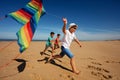 Color rainbow stripped kite hold by boys on beach Royalty Free Stock Photo