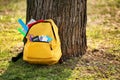 Color rucksack with school stationery on ground outdoors Royalty Free Stock Photo