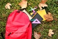 Color rucksack with school stationery on ground outdoors Royalty Free Stock Photo