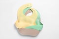 Color silicone baby bibs isolated on white, top view