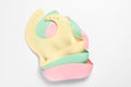 Color silicone baby bibs on white background, top view Royalty Free Stock Photo