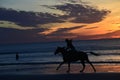 The color of sunrise envelopes a small group of horseback riders Royalty Free Stock Photo