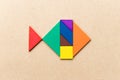 Color tangram in fish shape on wood background Royalty Free Stock Photo