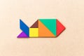 Color tangram puzzle in fish shape on wood background Royalty Free Stock Photo