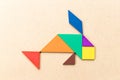 Color tangram in fish shape on wood background