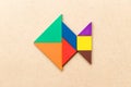 Color tangram in fish shape on wood background Royalty Free Stock Photo