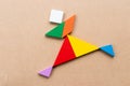 Color tangram in running or joy people shape on wood background