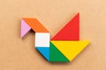 Color tangram in swan or duck shape on wood bacground