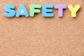 Color toy foam alphabet in word safety on cork board background Royalty Free Stock Photo