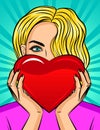 Color vector pop art style illustration of a girl holding a heart in her hands. Beautiful blonde with blue eyes holds a red heart. Royalty Free Stock Photo