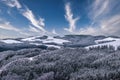 Winter panorama of a snowy countryside with forest, hills, farm buildings, fields, valleys Royalty Free Stock Photo