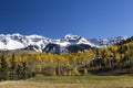 Colorado landscape with large house nestled among colorful trees and snow peaked mountains