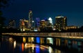 Colorado River or Lady Bird Lake colorful water reflections with Pedestrian Bridge in front of the Austin Texas Skyline Nightscape