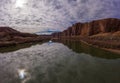 Colorado River and Red Sandstone Cliffs on Cloudy Day. Wall Street Rock Climbing Area. Clouds Reflection in Water. Grand Royalty Free Stock Photo