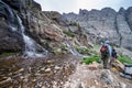 Hikers prepare to scramble up the slippery waterfall along the Sky Pond trail in Rocky Mountain