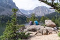 Man and woman hiker couple sit, relax and enjoy the view of Loch Vale lake in Rocky Mountain