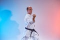 On a colored background, an adult athlete performs formal exercises