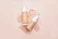 Bottles of makeup foundation and samples on color background Royalty Free Stock Photo