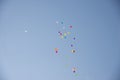 Colored balloons fly in the blue sky from happy people. Royalty Free Stock Photo