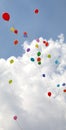 colored balloons fly into the sky with clouds during the party