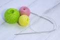 Colored balls for knitting and knitting needles lie on a white wooden background. copyspace. Royalty Free Stock Photo