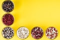 Colored bean in glass jars on a yellow background. Image with copy space