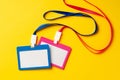 Colored blank nametags on strings on yellow background Royalty Free Stock Photo