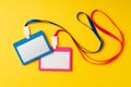 Colored blank nametags on strings on yellow background Royalty Free Stock Photo