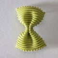 Colored bow tie pasta. Closeup single green farfalle Royalty Free Stock Photo