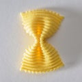 Colored bow tie pasta. Closeup single yelow farfalle Royalty Free Stock Photo