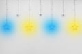 Colored bright garlands in the form of stars on a white empty wall of the interior background decor Royalty Free Stock Photo