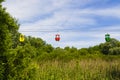 Colored cabins of cableway with summer landscape.